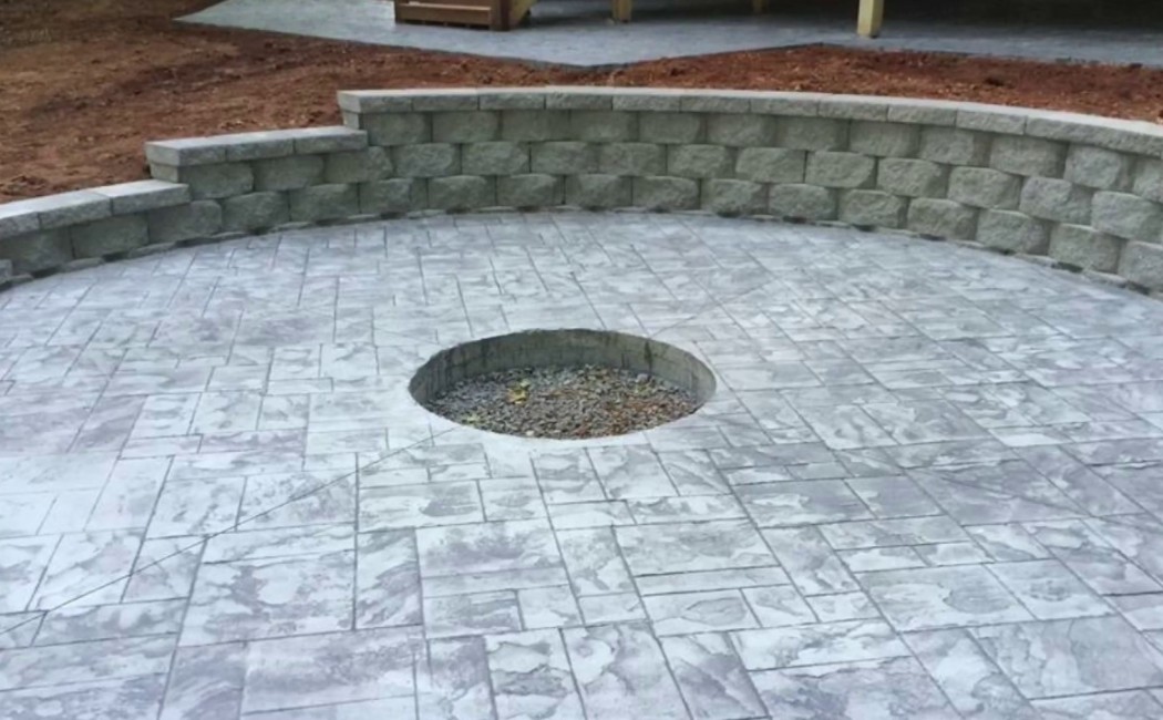 Custom outdoor patio with stamped concrete flooring and a built-in fire pit area, showcasing professional Decorative Concrete Services for durable and stylish outdoor designs.